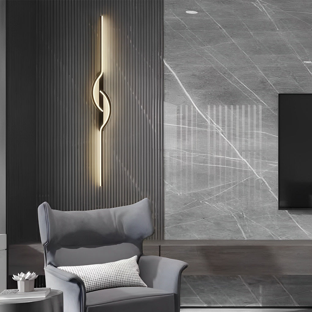 Vertical modern linear wall sconce creating ambient light in a contemporary reading corner.