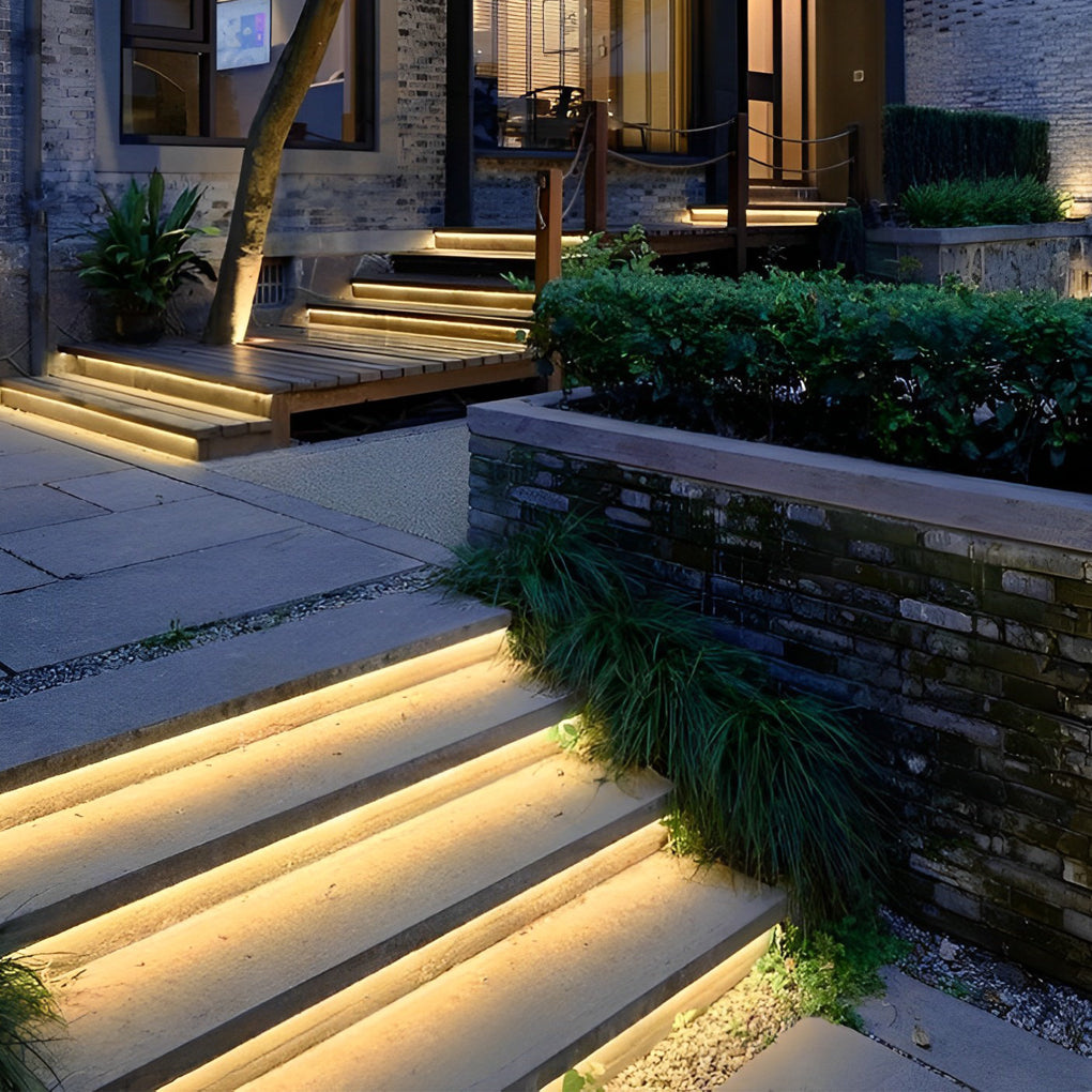 Outdoor stair lighting strips illuminating modern staircase edges with warm, ambient glow.
