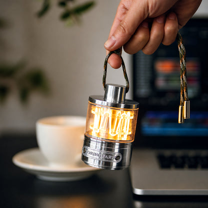 Heartbeat Glow portable lantern held in a refined workspace beside a laptop and coffee cup.