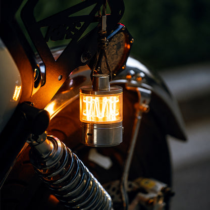 Heartbeat Glow portable lantern casting a warm light beside a motorcycle.