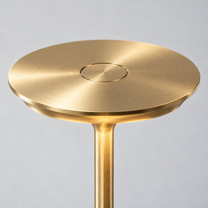 Close-up of a table lamp's brushed gold disc shade and inset circular touch control - Airayvis