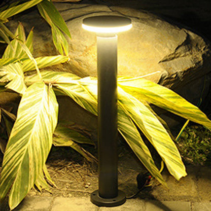 Bollard pathway lights illuminating plants and rocks in a garden, creating a cozy ambiance.