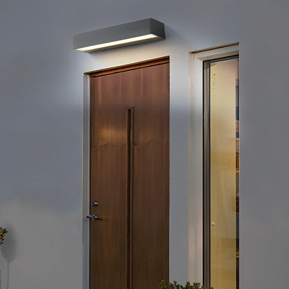 Contemporary exterior porch light fixtures mounted above wooden entry door with warm ambient glow.