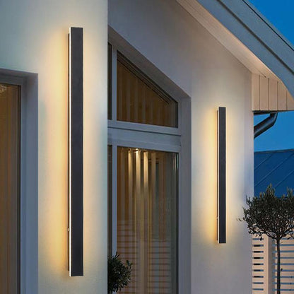 Outdoor strip wall light providing ambient light beside a glass door.