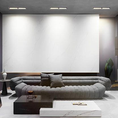 Recessed linear light fixtures installed in a modern living room ceiling